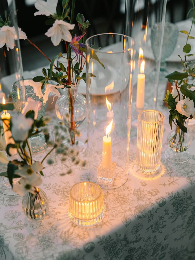 Candles flicker across tables for wedding reception