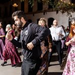 Wedding guests dancing energetically at an elegant Charlotte reception venue with chandelier lighting