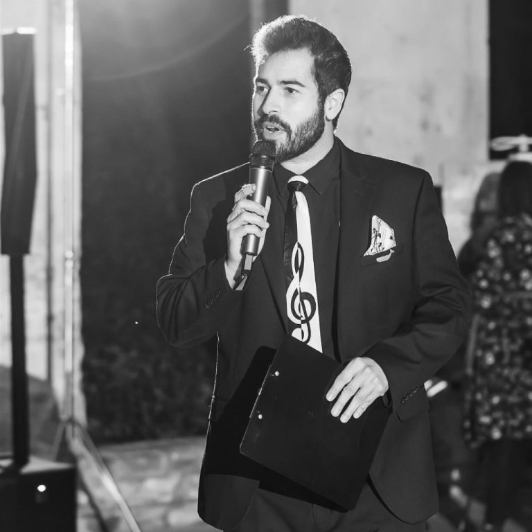 Charlotte wedding entertainment vendor in formal attire with microphone entertaining reception guests