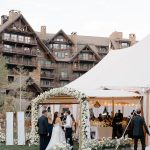 Colorado mountain wedding with elegant white tent structure and abundant white floral decor