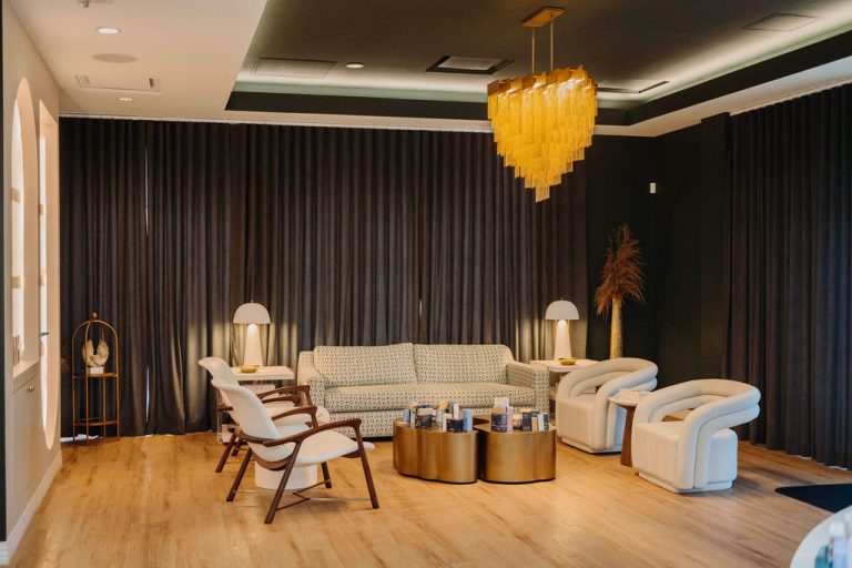 Chic Charlotte wedding reception venue with modern white furniture and striking gold heart chandelier centerpiece