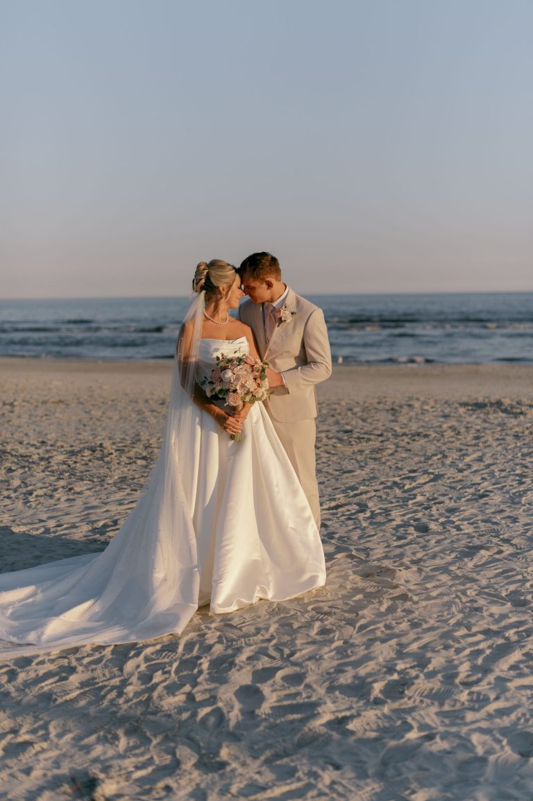 Bride and groom sharing intimate moment on coastal Georgia beach at golden hour