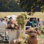 Outdoor Columbus wedding ceremony featuring organic hydrangea arrangements in pink, green and cream displayed in terracotta vessels.