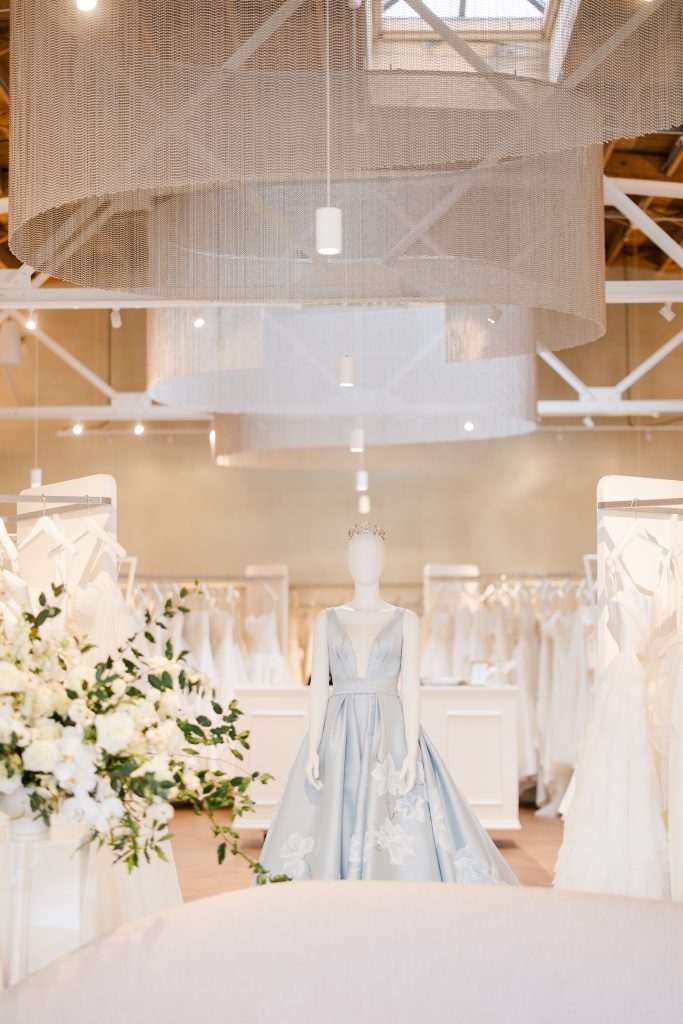 Bright bridal boutique interior with exposed beams, elegant seating, and white wedding gowns on display