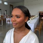 Natural bridal makeup with warm-toned eyeshadow, soft glow, and a sleek low ponytail hairstyle styled for a modern wedding day.