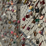 fence with different colored locks with hearts and initials on the locks