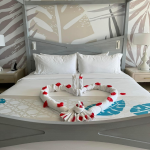 Honeymoon suite bed with towel swans arranged in heart shape with rose petals