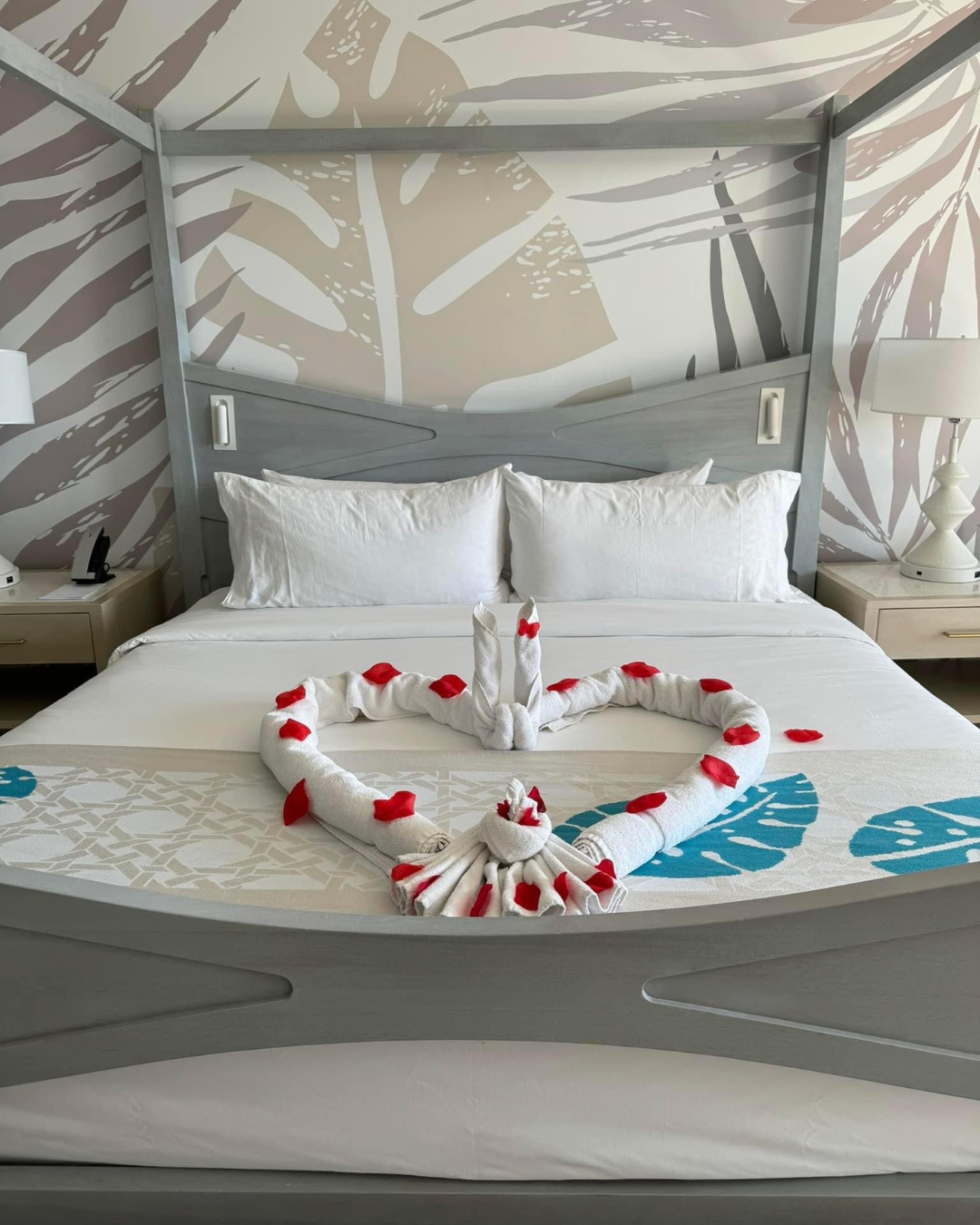 Honeymoon suite bed with towel swans arranged in heart shape with rose petals