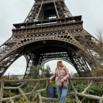 Travel agent posing in front of the Eiffel Tower in Paris during autumn