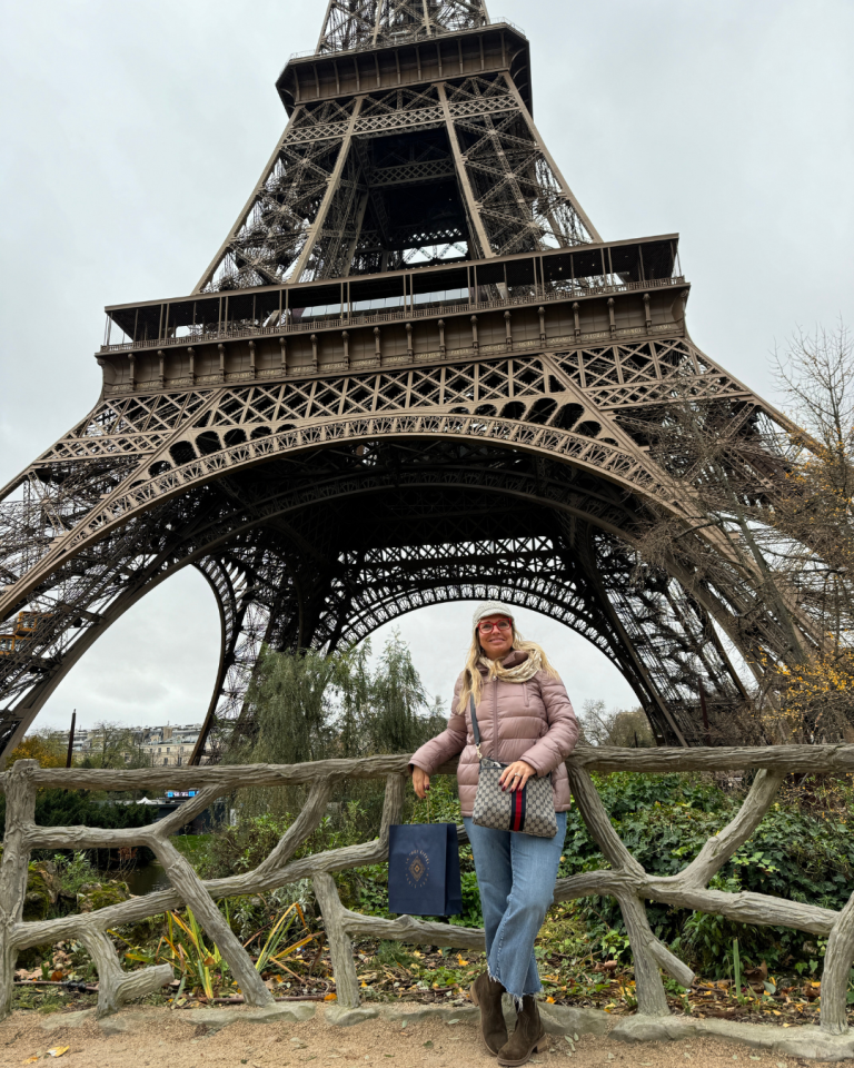 Travel agent posing in front of the Eiffel Tower in Paris during autumn