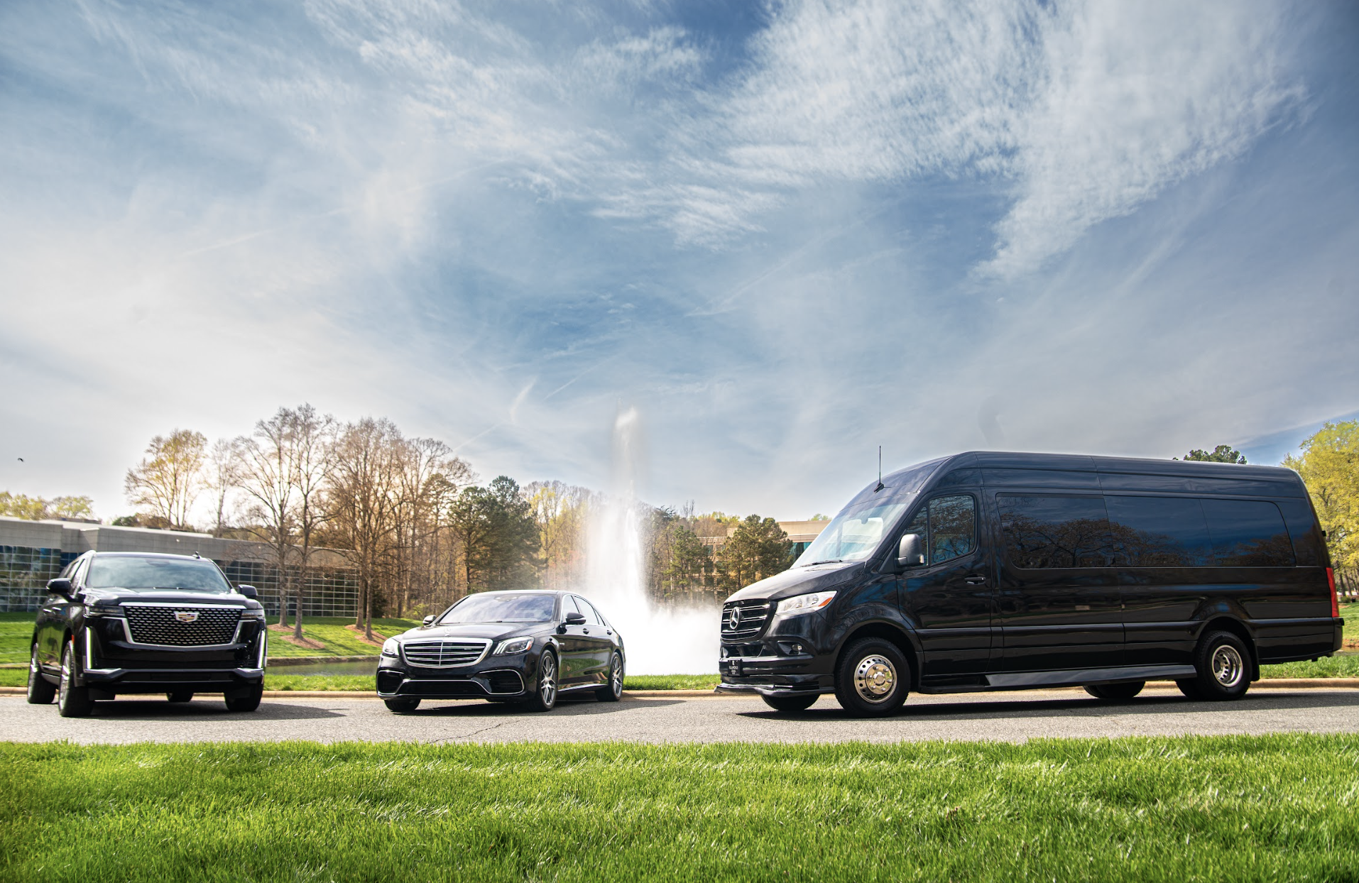 Fleet of luxury wedding vehicles including SUV, sedan, and sprinter van at outdoor venue