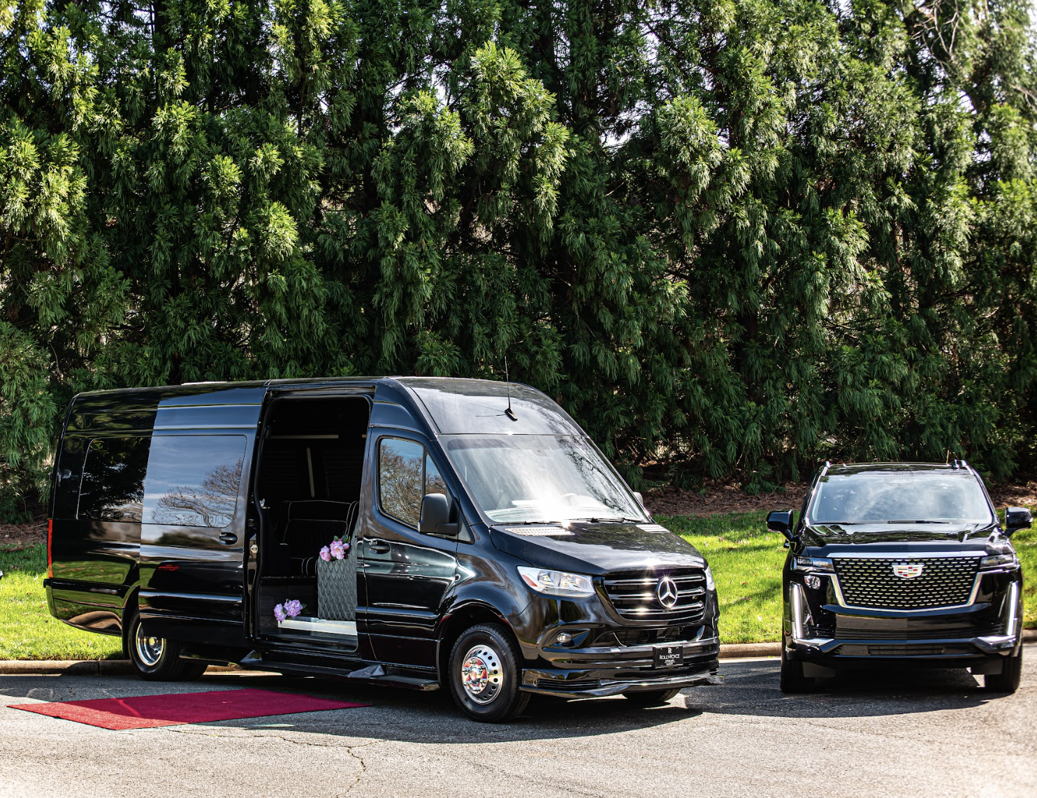 Black Mercedes sprinter van and Cadillac SUV on red carpet for wedding party transportation