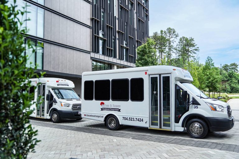 Riches & Roses branded white shuttle buses parked at modern building for wedding transportation service