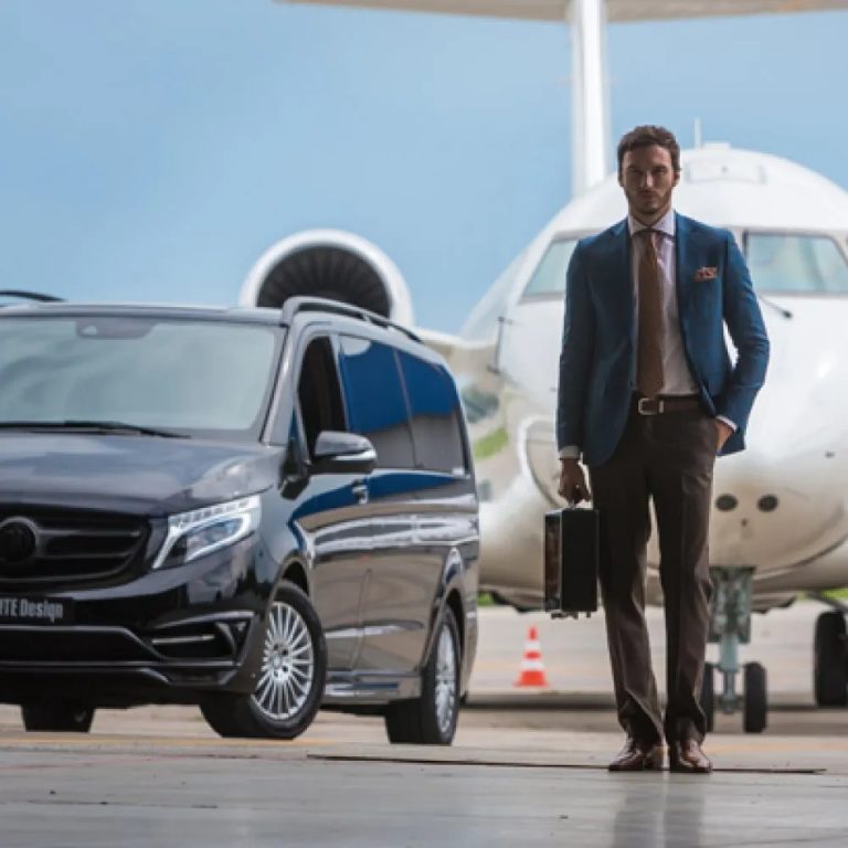 black transportation van and airplane in the background of man walking away with briefcase