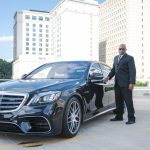 luxury transportation car with chauffer holding door