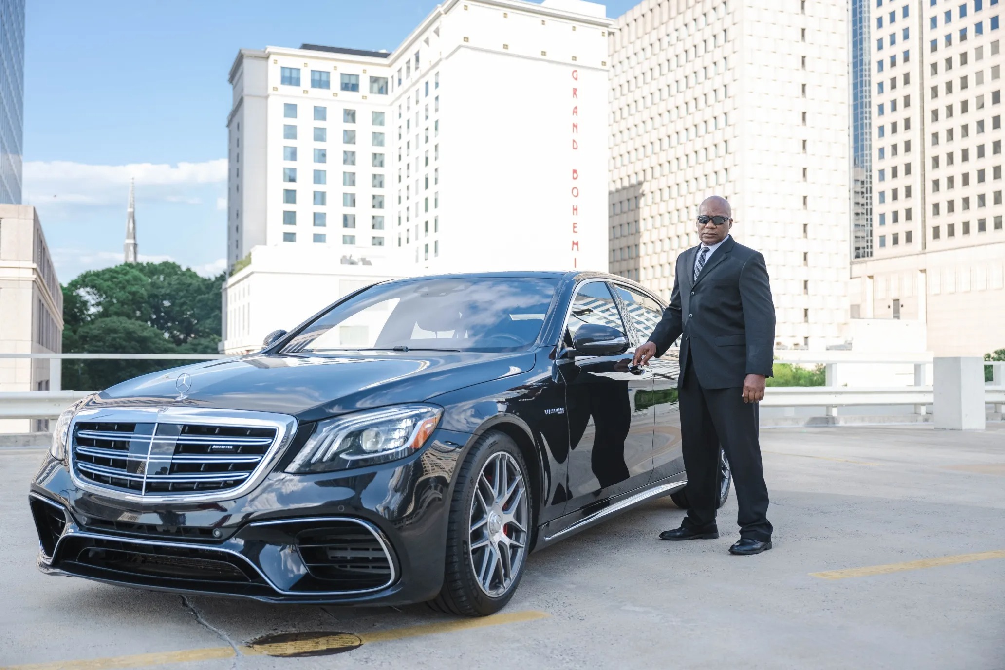 luxury transportation car with chauffer holding door