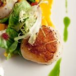 Upscale venue-style appetizer featuring seared salmon crostini with fresh garnish