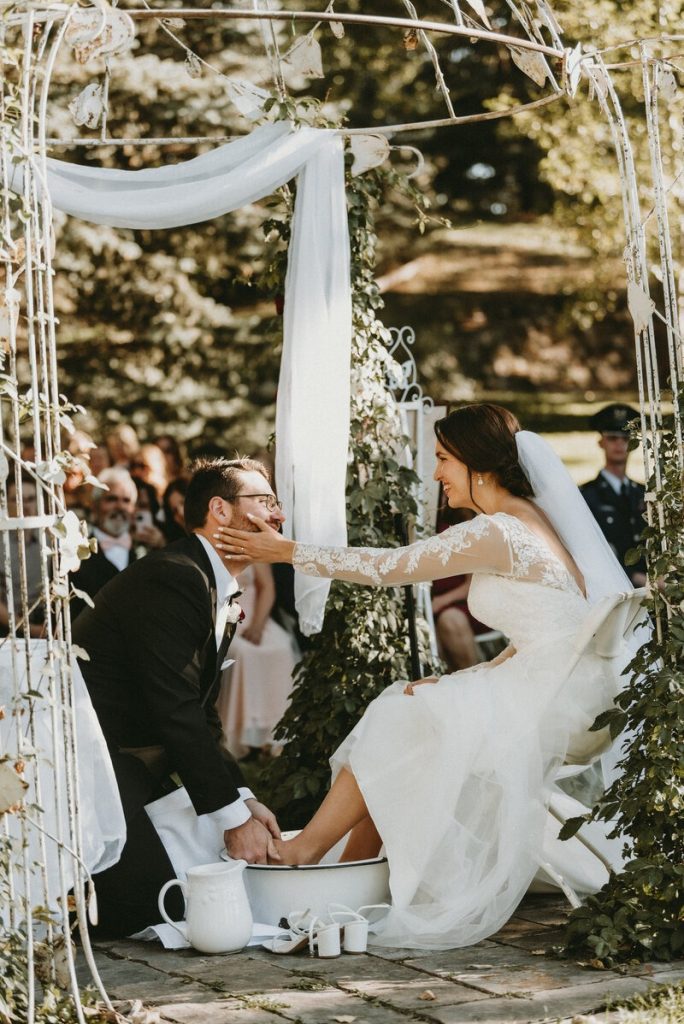 Newlyweds laughing together under macrame ceremony backdrop