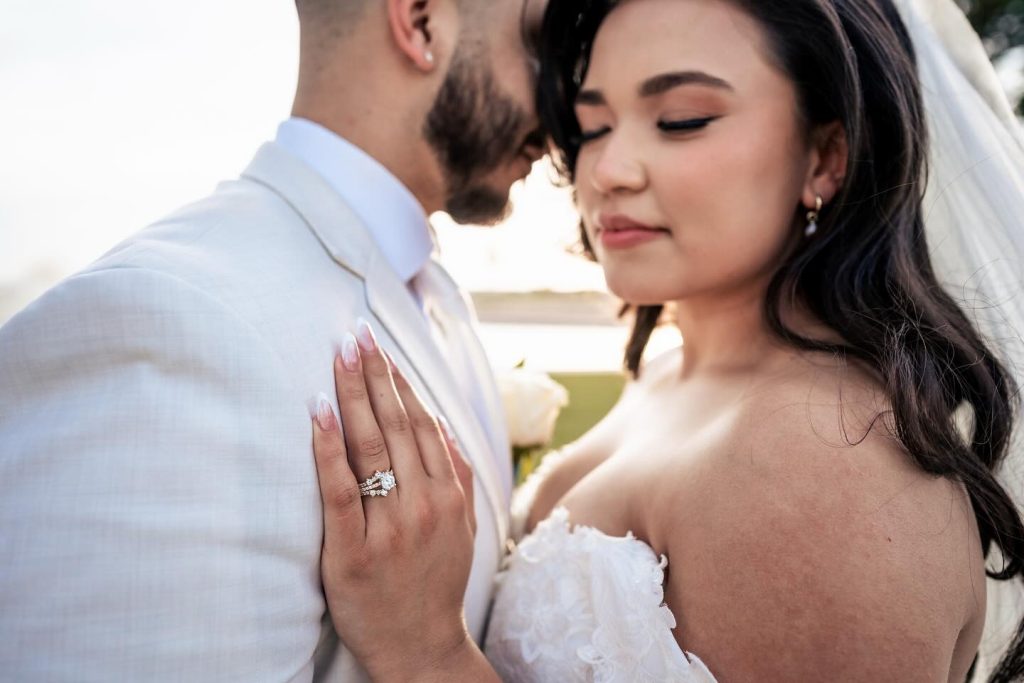 Bride with diamond engagement ring embracing groom in intimate wedding moment