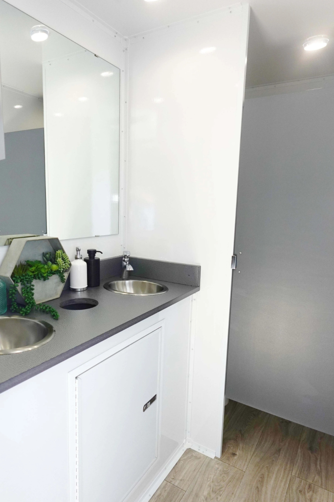 Wedding centerpiece with white roses, baby's breath, and blue delphinium on reception table with light blue linens