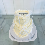 two tiered white heart engagement cake with bow details