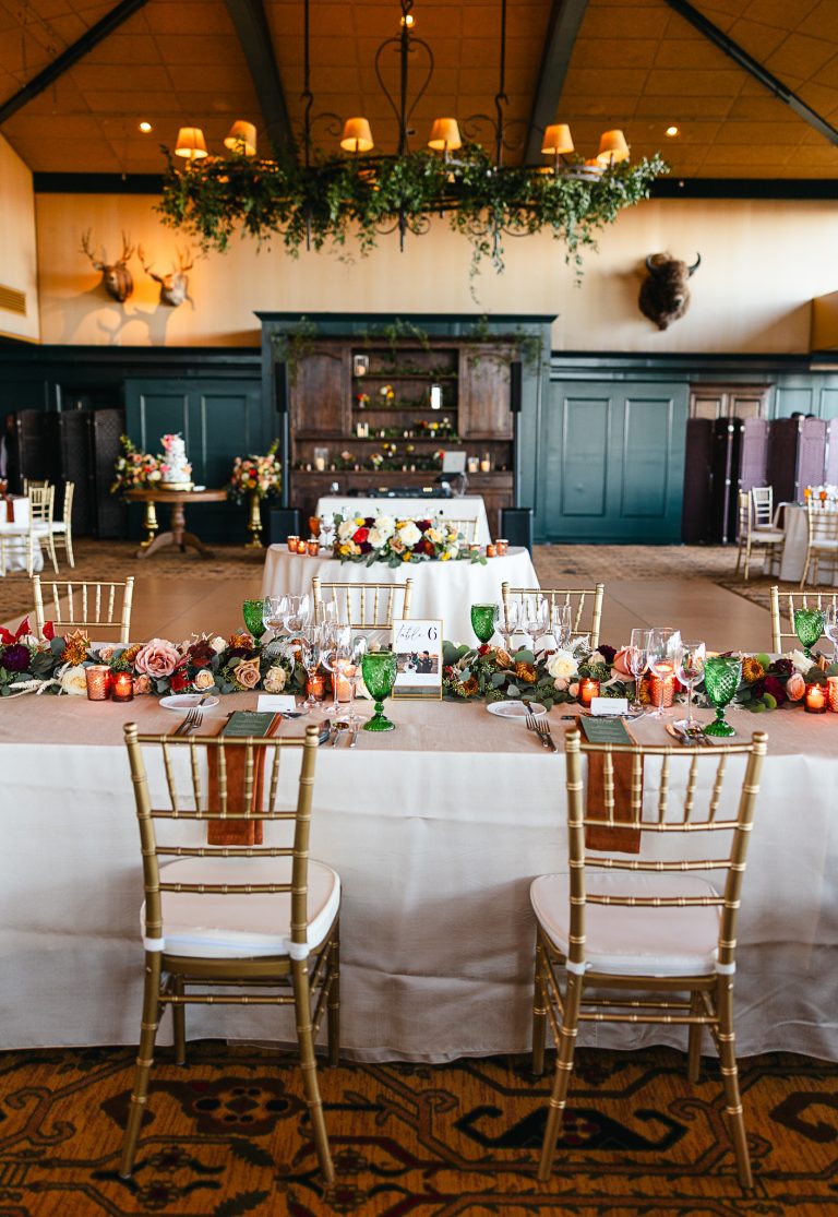 Rustic wedding reception venue with gold chairs and floral arrangements