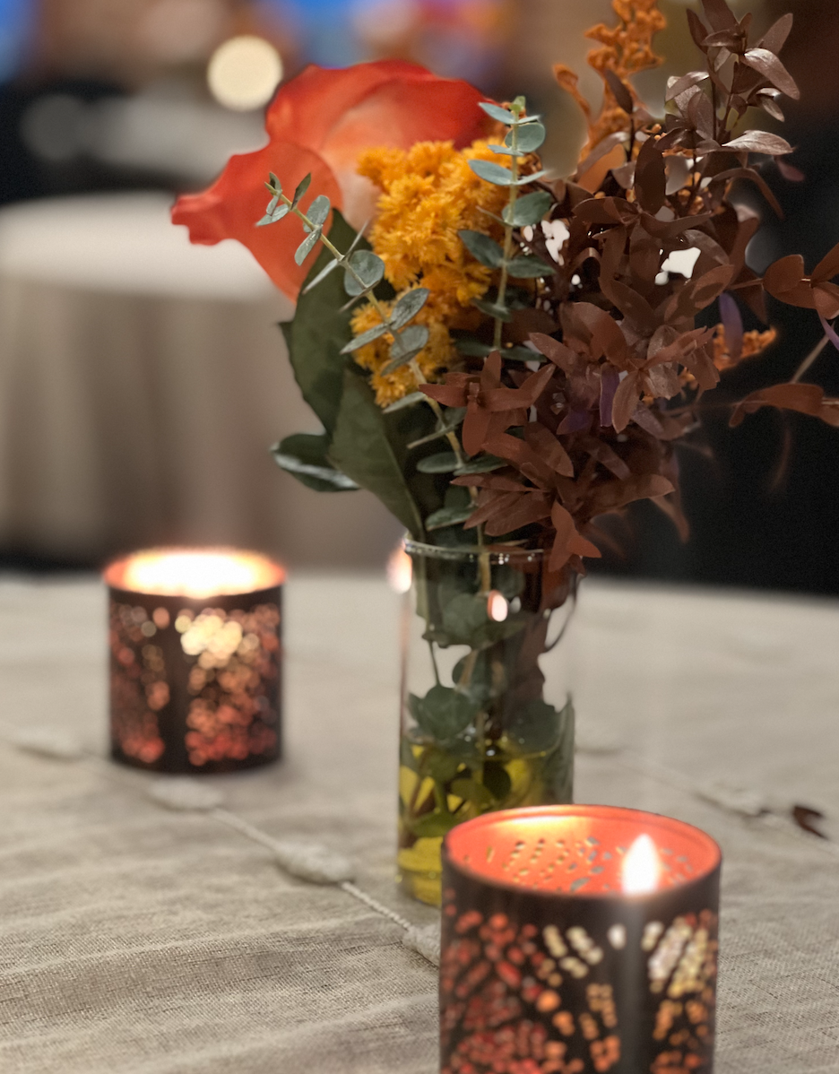 Fall-themed table centerpiece with dried flowers and lit decorative candles at Sunset Parlor venue