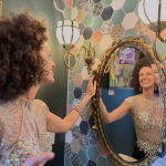 Bride admiring reflection in ornate mirror at Sunset Parlor getting-ready suite