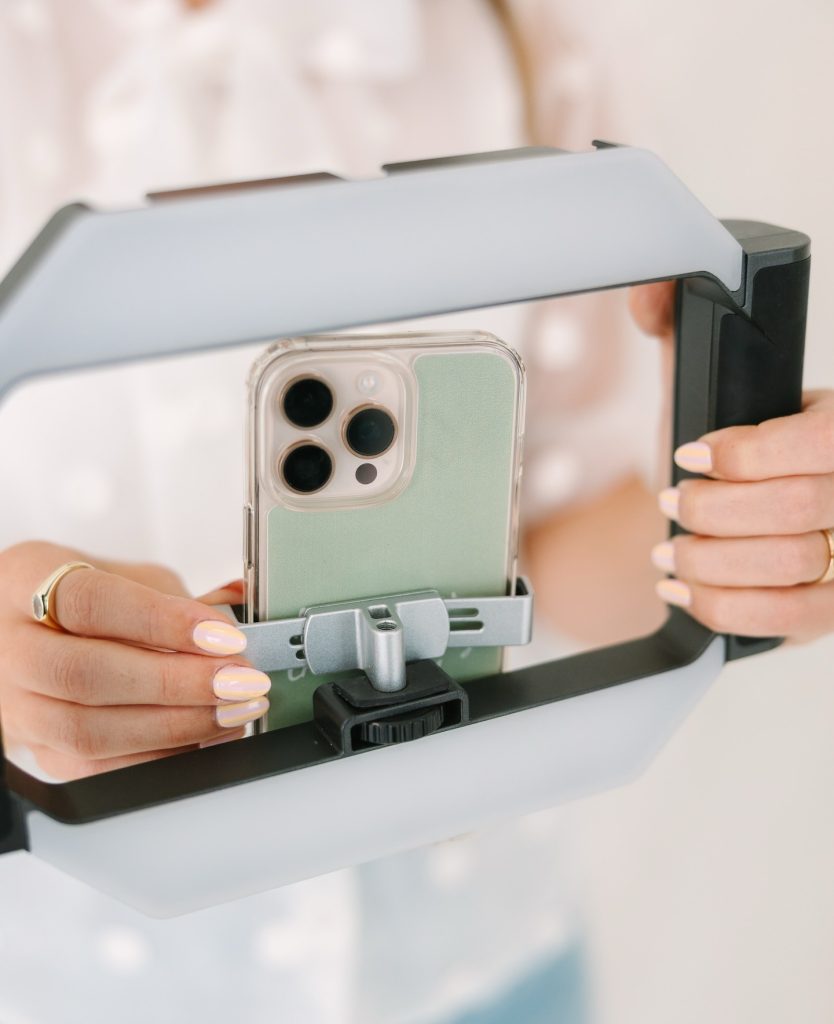 Hands holding smartphone in portable video rig for wedding content creation