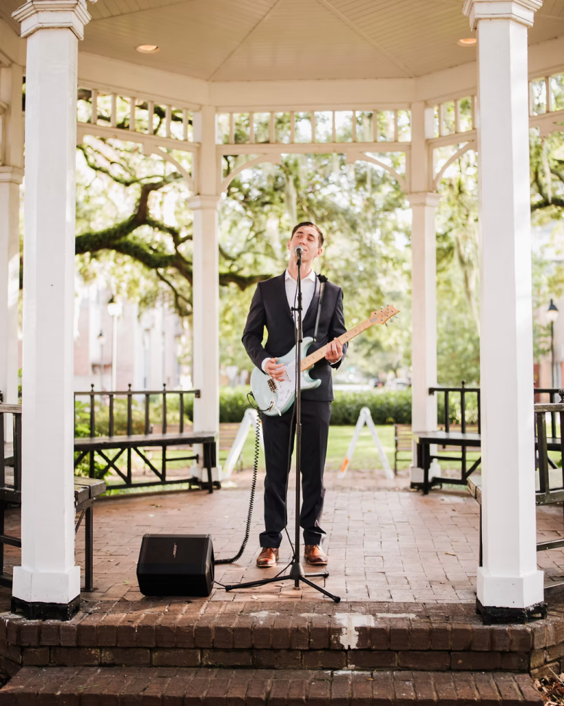 Live musician performing with guitar in white gazebo at Savannah wedding venue
