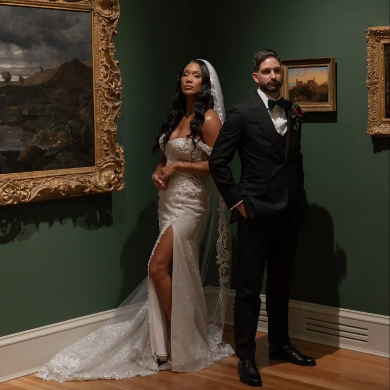 Newlywed couple in elegant formal wear in sophisticated venue with ornate gold accents