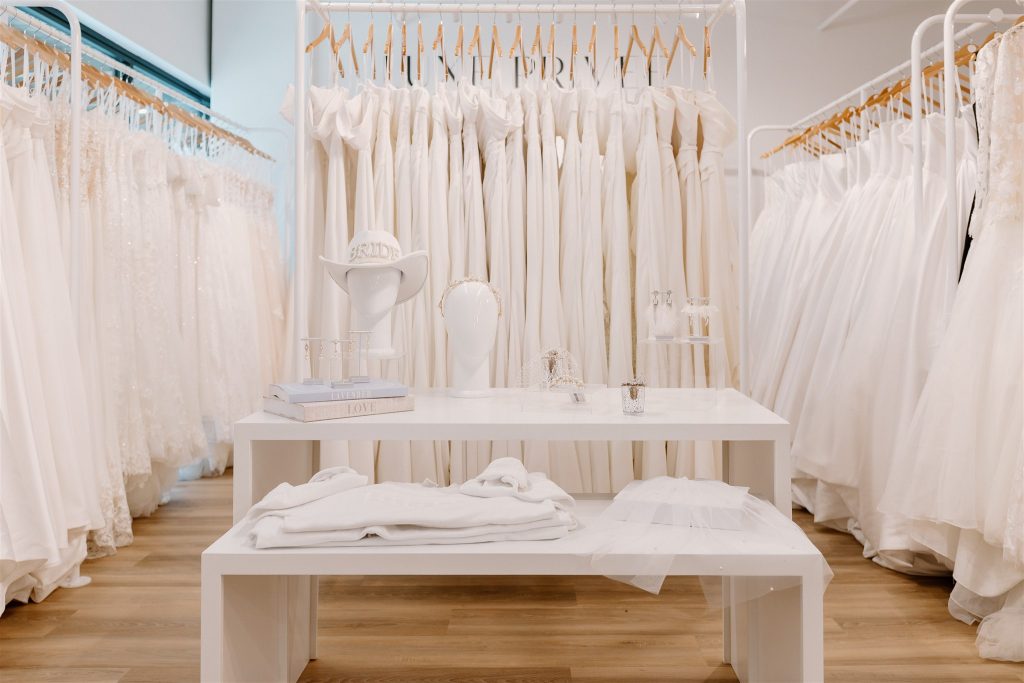 Bridal boutique interior with white wedding gowns displayed on racks