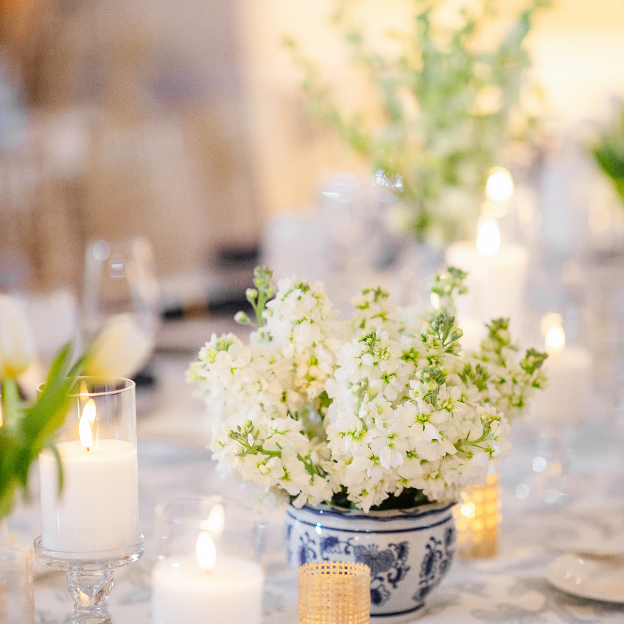White and green floral centerpiece with baby's breath in blue and white chinoiserie vase on wedding reception table