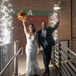 Newlyweds celebrate their grand exit with sparklers in industrial brick venue