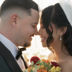 Couple shares intimate moment at sunset with colorful bridal bouquet