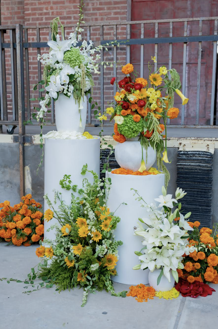 Modern white cake setup featuring white and orange floral decorations on multiple levels