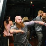 Wedding guests celebrating and dancing energetically at reception