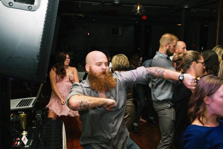 Wedding guests celebrating and dancing energetically at reception