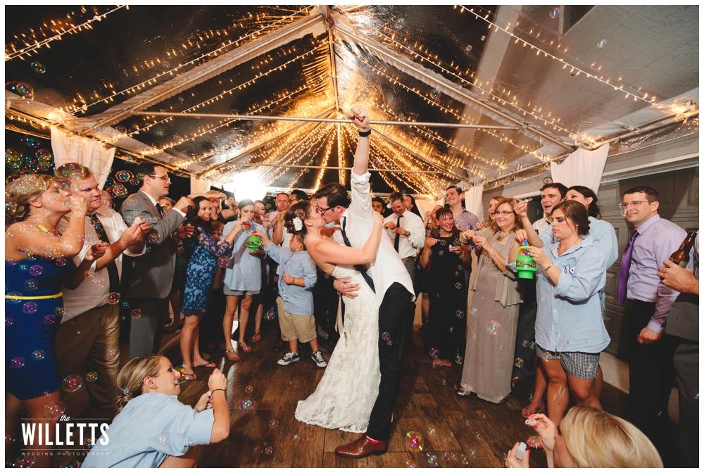 Wedding guests dancing under string lights at outdoor reception venue