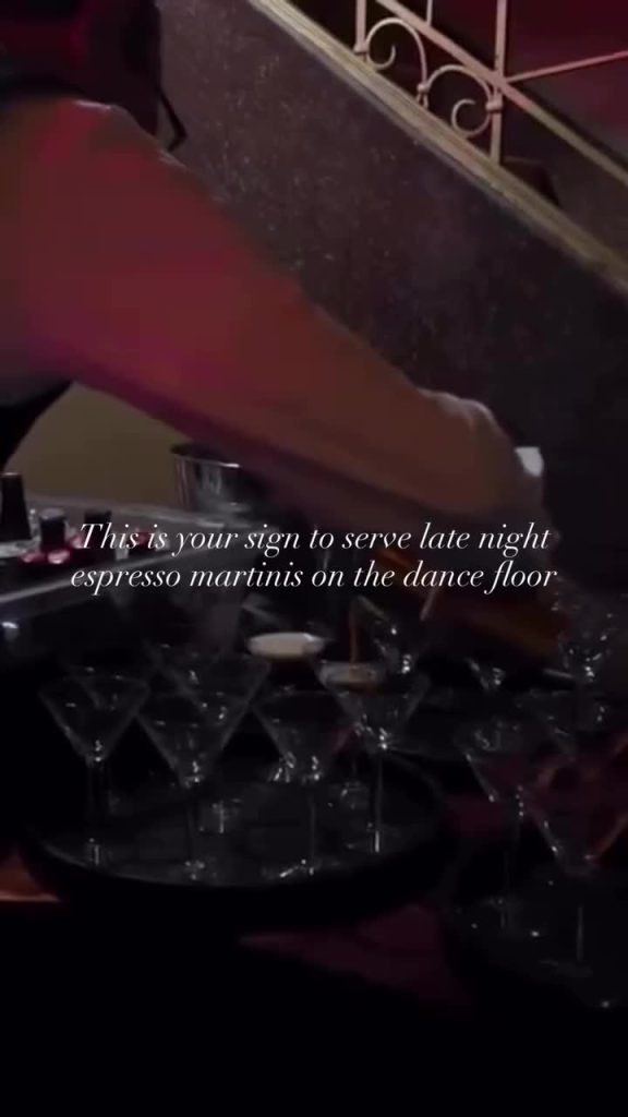 Hand pouring espresso martinis from shaker into cocktail glasses arranged on decorative tray