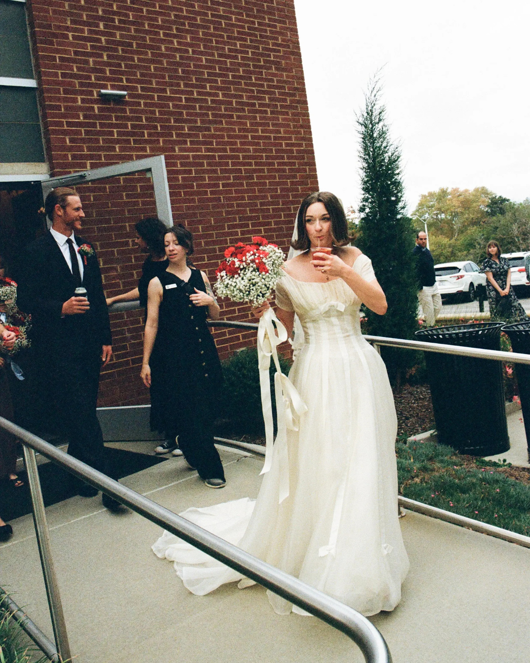 Bride holding a bouqet and a drink