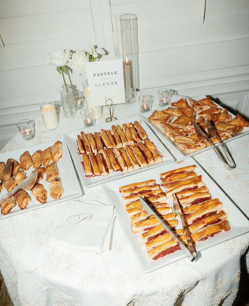 Elegant dessert table featuring assorted pastries and puff pastries with candles and white flowers