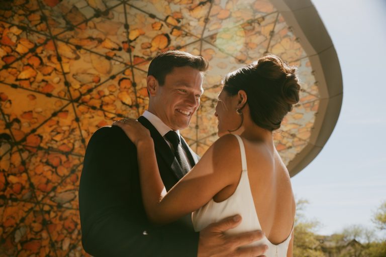 Bride and groom share an intimate moment outdoors with golden sunlight in the background