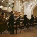 Modern event space interior featuring arched doorway, marble dining table, and contemporary design elements