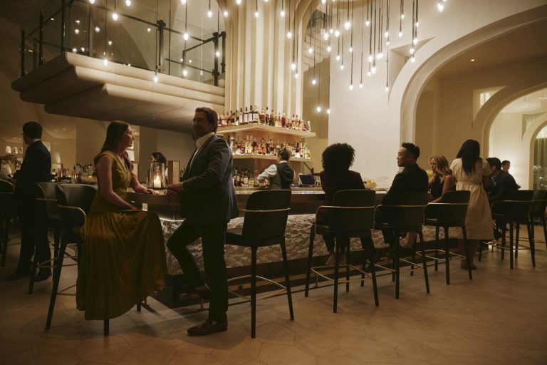 Modern event space interior featuring arched doorway, marble dining table, and contemporary design elements