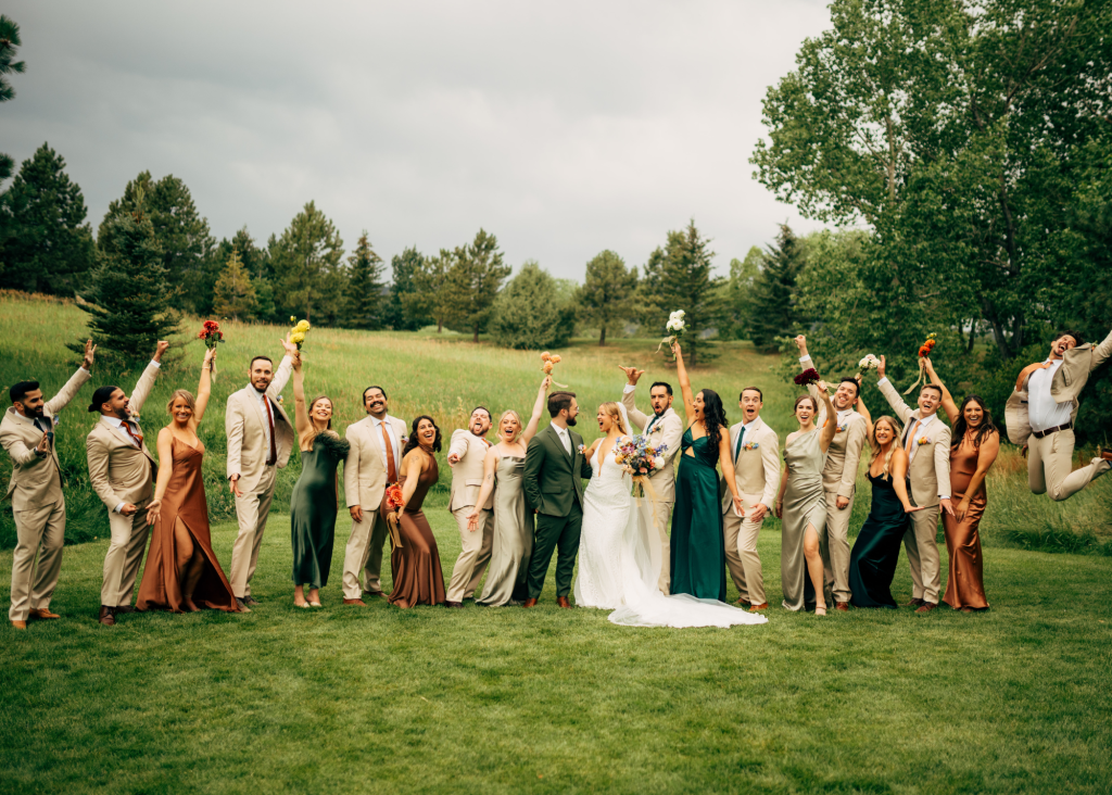 Lauren and Adam's wedding party celebrating on golf course with bride and groom in center