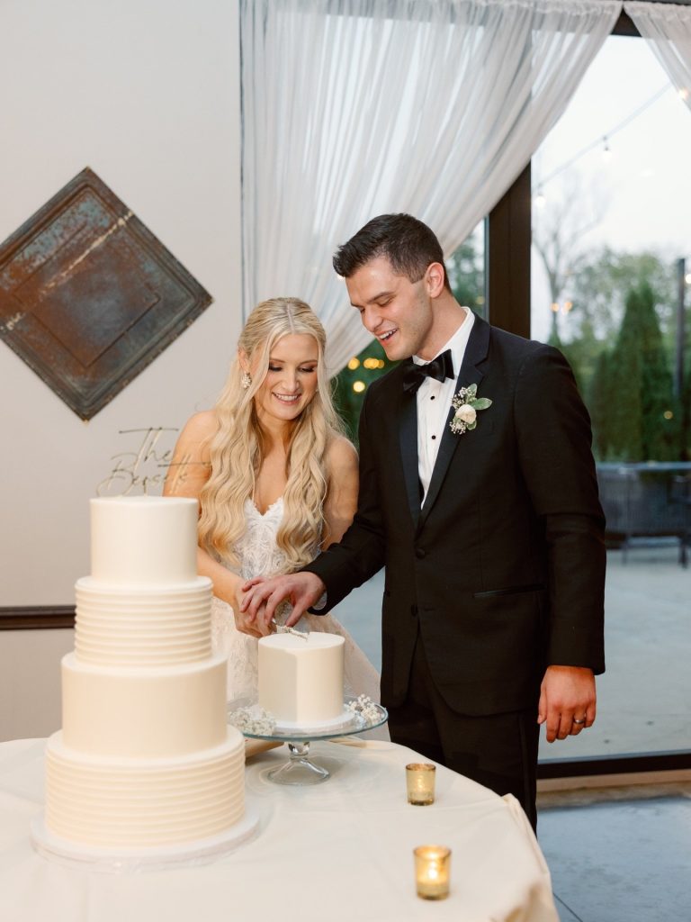 Katie and Steve cutting their three-tier white buttercream wedding cake with textured frosting