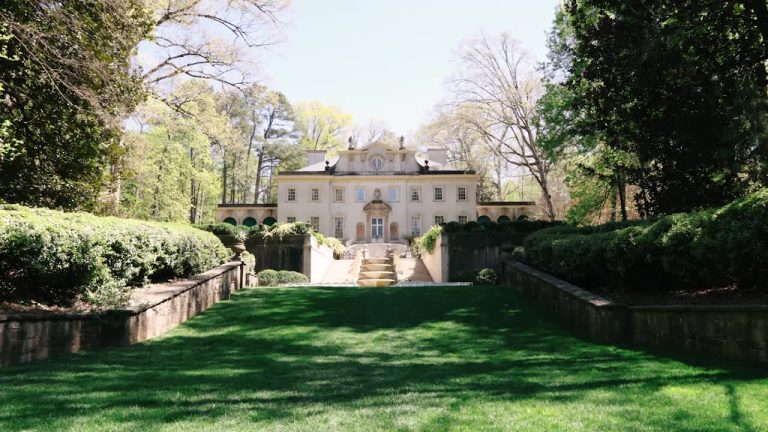 Classic estate wedding venue with manicured lawn and symmetrical architecture surrounded by mature trees