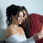 Bride in white lace wedding dress with elegant updo hairstyle smiling during getting ready preparations