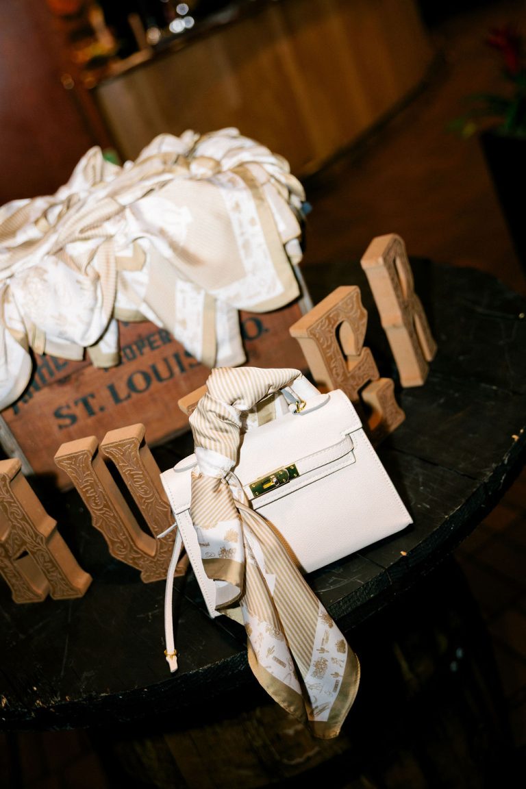 Wooden favor boxes with personalized tags tied with ribbon alongside white flowers